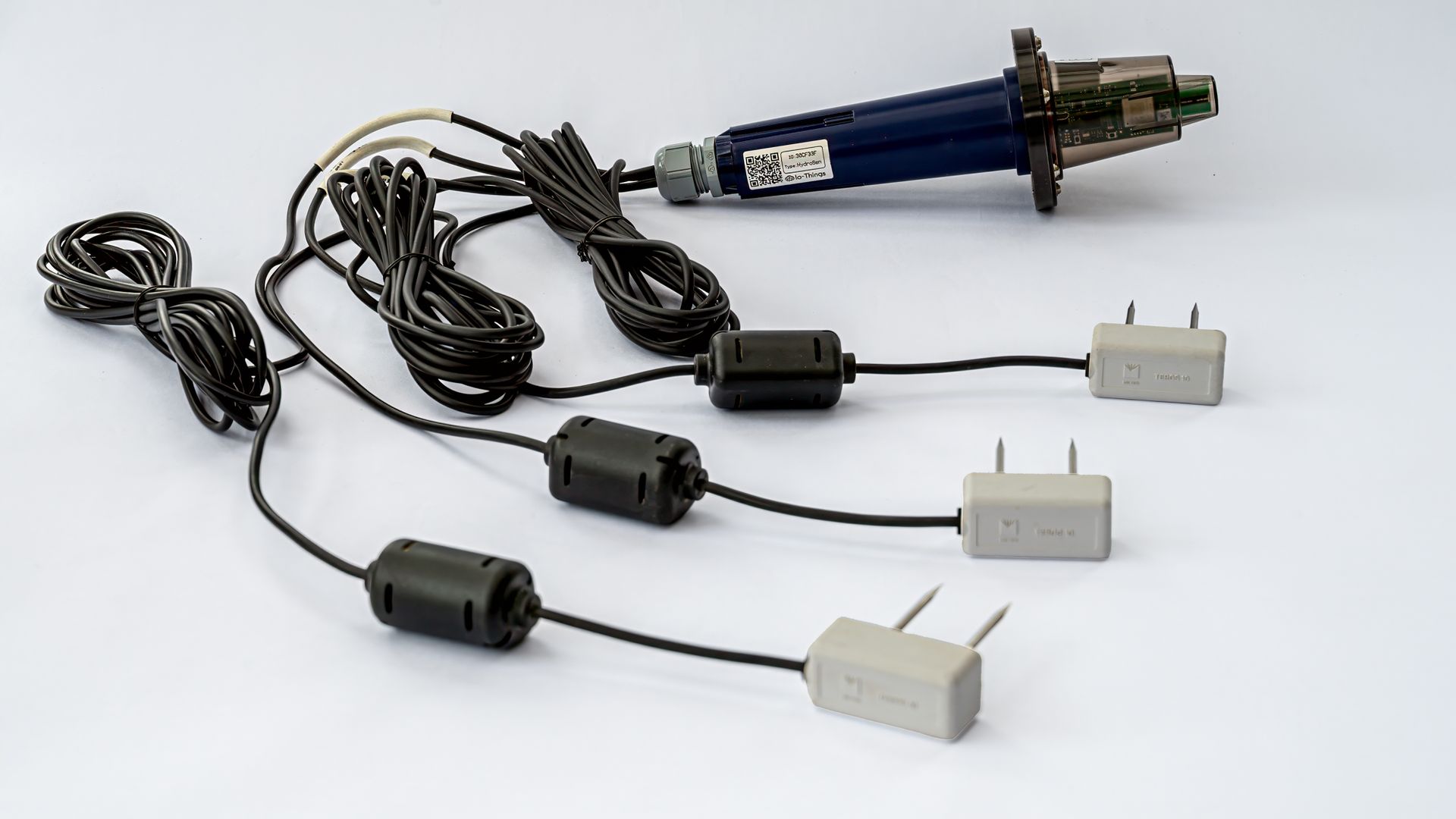 Een HydrioSense-node met drie Teros 10-bodemvochtsensoren eraan, elk aan een eigen kabel, voor drie meetpunten naast elkaar in dezelfde wortelzone