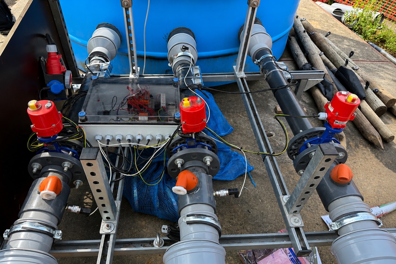 De sturing op het influentvat: drie elektrisch bediende kleppen met rode actuatoren op het leidingwerk, met de stuurkast in een transparante behuizing ertussen